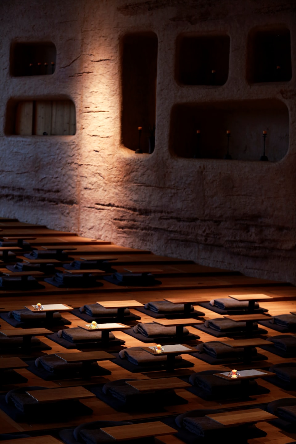 Empty meditation room with cushions and candles on the floor.