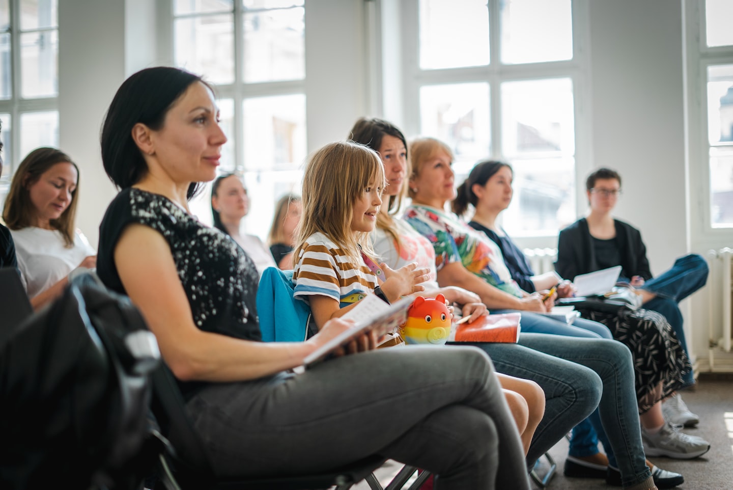 Girl gestures enthusiastically at an indoor business seminar.